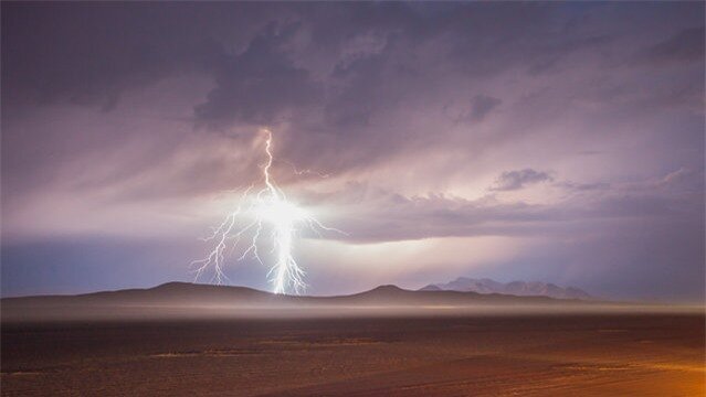 “Desert Flash”. A flash of lightning cuts through darkness during the early morning storms which drenched the Black Rock Desert and immobilized the entrance line to Burning Man 2014. Photo location: Black Rock Desert, Nevada. (Photo and caption by Jesse Rather/National Geographic Photo Contest)