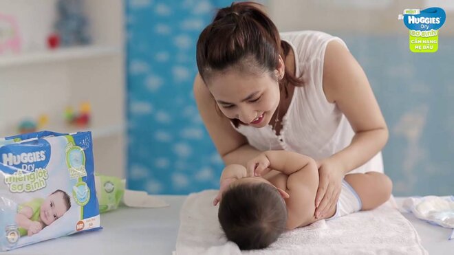 Cho bé nằm ngay ngắn khi thay tã dán Huggies cho bé