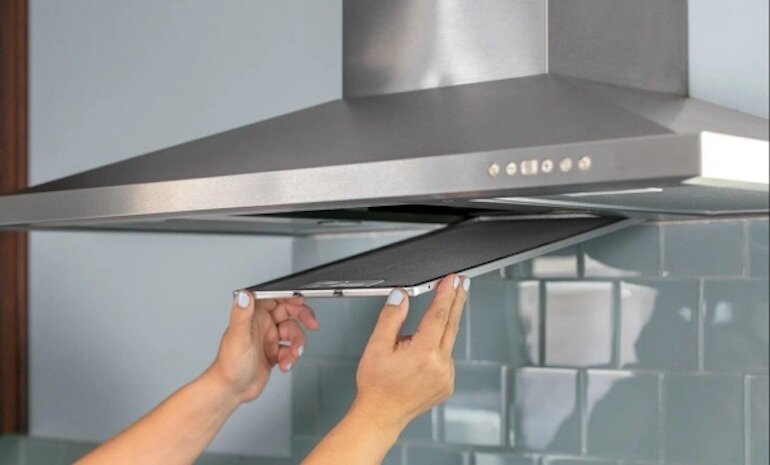 Tháo rời các tấm lưới lọc mỡ khỏi máy hút mùi