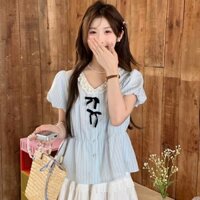Áo sơ mi babydoll tay phồng, họa tiết kẻ sọc, đính kèm nơ, phong cách dịu dàng với 2 màu xanh, vàng.