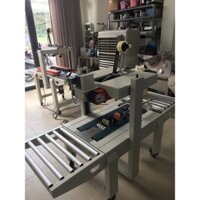 Máy dán băng keo thùng hai mặt FXA6050, máy dán băng keo thùng giấy, máy dán thùng carton, thùng nước ngọt,thực phẩm
