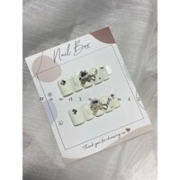 móng tay giả thiết kế form vuông ngắn đính charm nơ đá màu trắng sữa